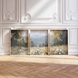 May include: Three framed landscape paintings. The artwork depicts a serene outdoor scene with trees, a path, and white flowers. The colour palette includes greens, yellows, and blues, creating a calming aesthetic. The frames are a light neutral colour.