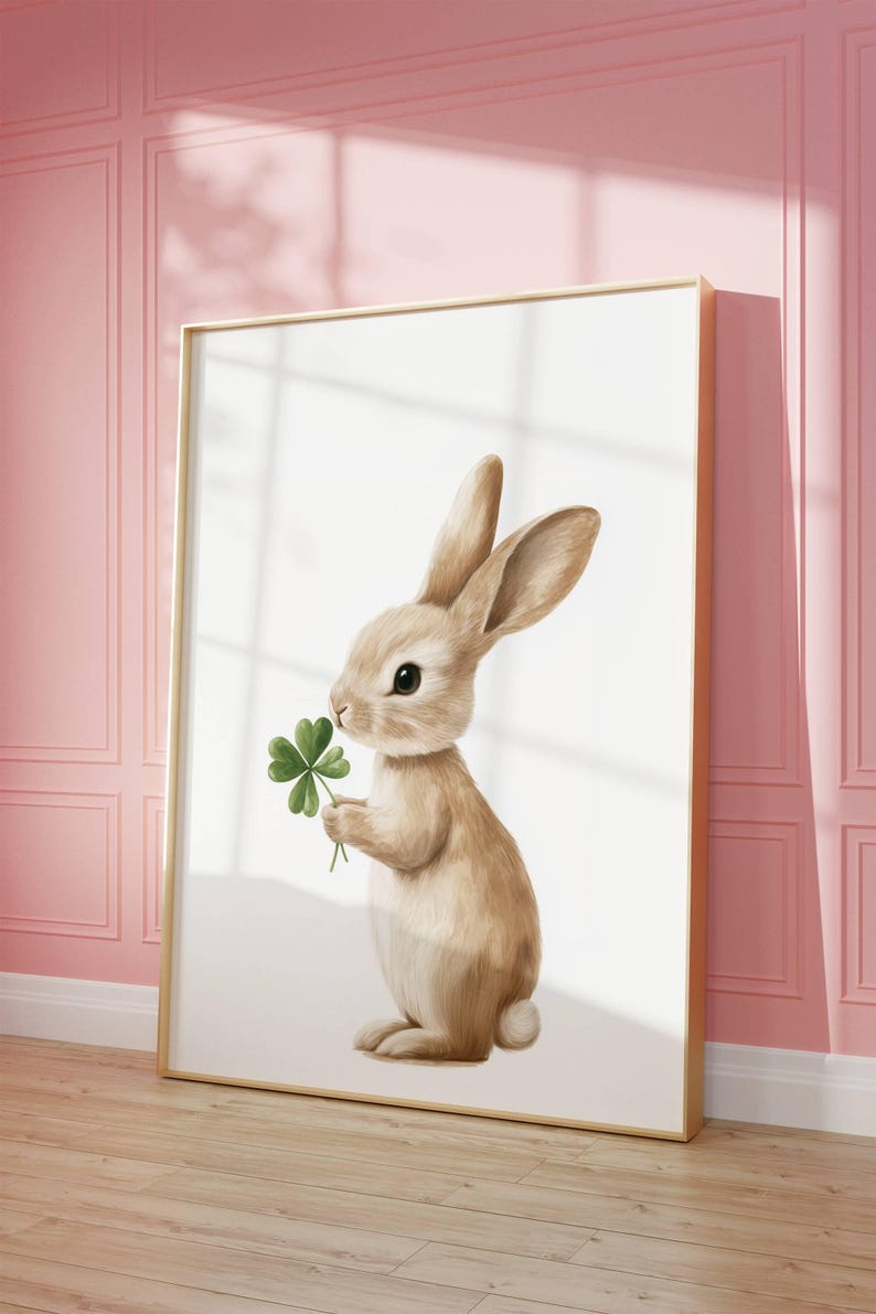 May include: A brown bunny rabbit holding a green four-leaf clover in its paws. The bunny is standing on a white background.