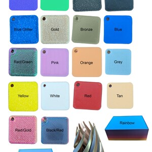 May include: A collection of 18 small square plastic tiles in various colours and finishes, including solid colours, glitter, and metallic finishes. The tiles are arranged in a grid pattern. The colours include purple, green, black glitter, black, blue glitter, gold, bronze, blue, red/green, pink, orange, grey, yellow, white, red, tan, red/gold, and black/red. There are also two additional items: a rainbow-coloured plastic tile and a silver, gold, and copper metallic tile.