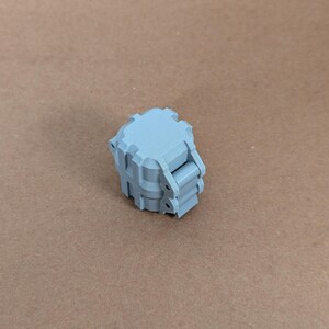 May include: A light grey plastic box with a hinged lid. The box has a textured surface and is designed to be used as a storage container.