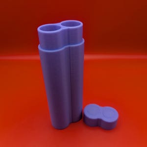 May include: A purple double-ended container with a lid. The container is made of plastic and has a smooth finish.