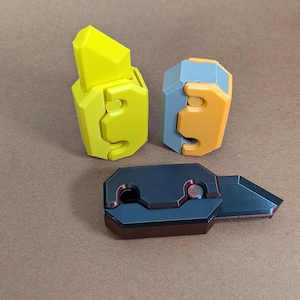 May include: Three different types of utility knives with different colored handles. The first knife has a yellow handle, the second knife has a gray and orange handle, and the third knife has a black handle.