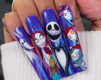 Puede incluir: Uñas largas, moradas y brillantes con un tema de Pesadilla Antes de Navidad. Cada uña presenta un personaje diferente de la película, incluyendo a Jack Skellington, Sally y Zero.