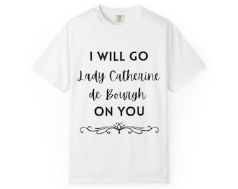 May include: White t-shirt with the text "I WILL GO Lady Catherine de Bourgh ON YOU" in black script. A decorative flourish is below the text. The shirt is a crew neck style.