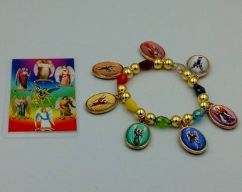May include: A gold bracelet with colorful beads and oval charms featuring images of angels. The bracelet is accompanied by a card with images of angels.