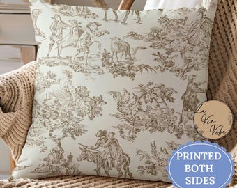 May include: Square throw pillow with a cream background and a brown toile pattern featuring figures, animals, and floral elements. The pillow is printed on both sides, as indicated by the text on the image. A decorative accent for a living room or bedroom.