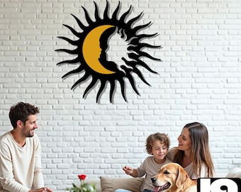 Puede incluir: Una decoración de pared de sol y luna negra y amarilla con un rostro humano estilizado. La decoración está colgada en una pared de ladrillo blanco. Una familia con un perro está sentada en un sofá en primer plano.