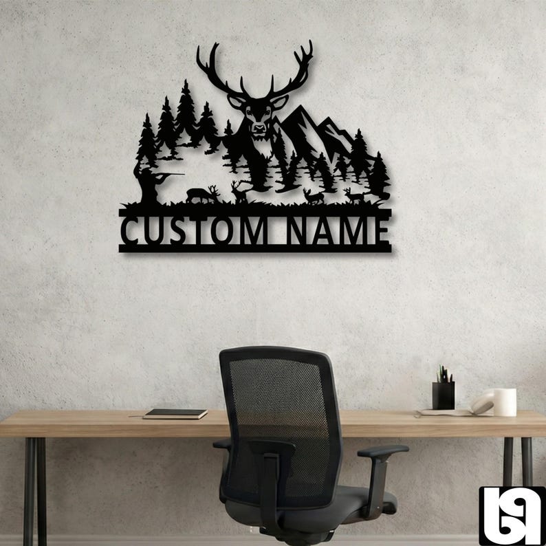 May include: Black metal wall art featuring a deer with large antlers, mountains, and trees. A hunter is depicted in the forest. The text "CUSTOM NAME" is below the scene. The art is displayed on a light gray wall.