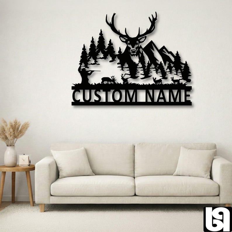 May include: Black metal wall art featuring a deer with large antlers, mountains, and trees. A hunter is aiming a rifle. The text "CUSTOM NAME" is below the scene. This decorative piece is suitable for a cabin or lodge.
