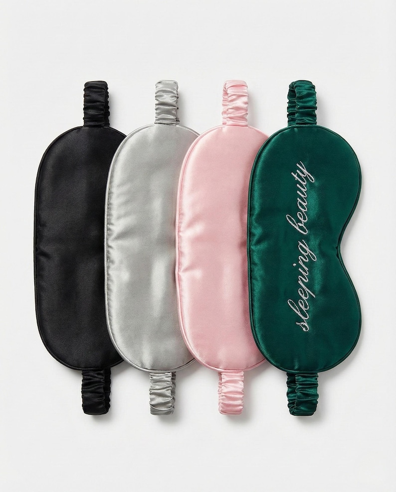 Puede incluir: Cuatro antifaces de sat&eacute;n en negro, plateado, rosa y verde esmeralda. El antifaz verde esmeralda tiene bordadas en blanco las palabras "sleeping beauty". Cada antifaz tiene una banda el&aacute;stica a juego.