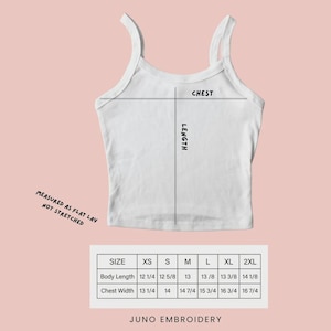 Pu&ograve; includere: Una canotta bianca con una tabella delle taglie che mostra le misure in pollici dalla XS alla 2XL. Il grafico include etichette per torace e lunghezza, con il testo measured as flat lay not stretched e JUNO EMBROIDERY in fondo all'immagine.