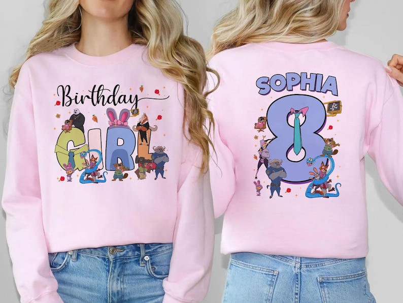 K&ouml;nnte beinhalten: Hellrosa Sweatshirt mit Aufdruck "Birthday GIRL" auf der Vorderseite und "SOPHIA 8" auf der R&uuml;ckseite. Das Design zeigt Cartoon-Figuren und den Schriftzug "Birthday" in Schreibschrift. Auf dem R&uuml;cken befindet sich eine gro&szlig;e 8.