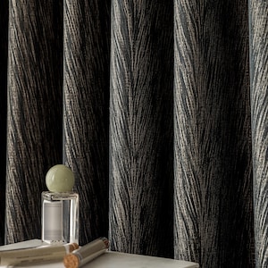 May include: Dark, textured curtains with a feather-like pattern in black and gold tones. A clear perfume bottle with a green orb-shaped stopper sits on a white book, with two small glass vials with cork stoppers.
