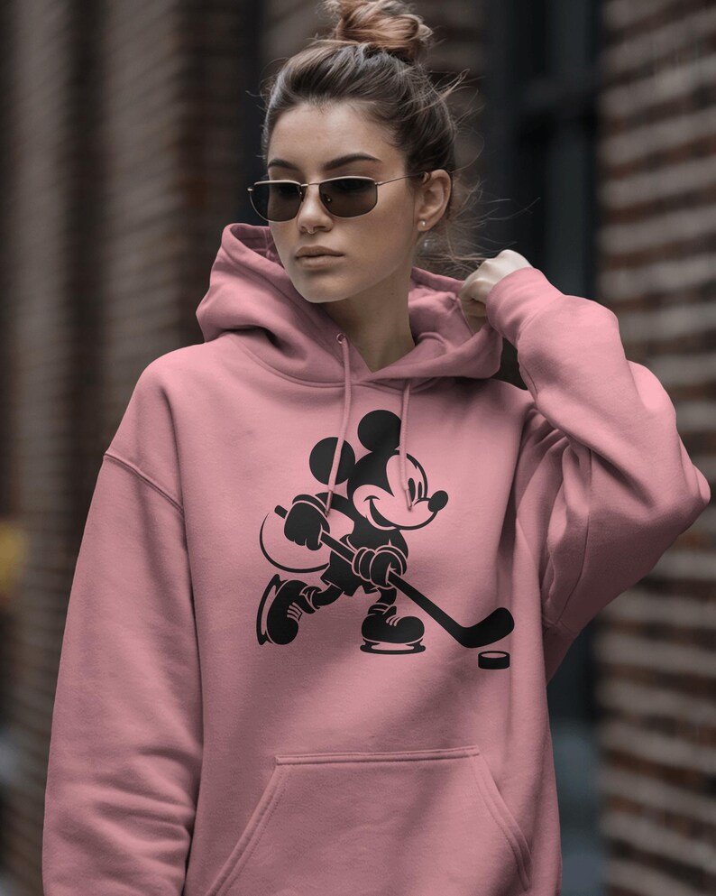 Ice hockey-themed design featuring Mickey Mouse with hockey player silhouettes and clipart. Includes SVG and PNG files, perfect for crafting, t-shirts, and sports-themed decorations. Ideal for Disney fans creating fun, hockey-inspired projects.