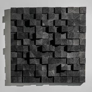 May include: A square, textured wall art piece composed of numerous dark gray wooden blocks. The blocks are arranged in a mosaic pattern, creating a dimensional effect. The wood grain is visible on the surface of each block, adding visual interest.