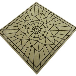 May include: A square rug with a floral design. The rug has a light green background with a black geometric pattern. The pattern is a large flower shape in the center, surrounded by a square border.