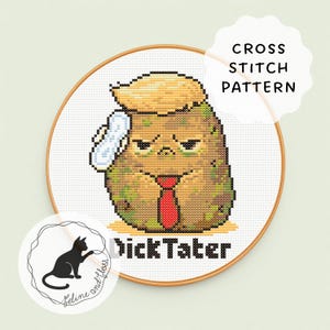 Op de afbeelding: Kruissteekpatroon met een cartoon aardappel met een blonde coupe, rode stropdas en een verband. Het ontwerp is geplaatst in een houten borduurring, met de tekst "NickTater" eronder.