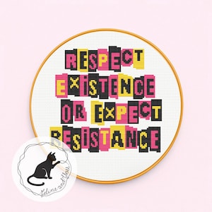 May include: A cross-stitch hoop with the words "RESPECT EXISTENCE OR EXPECT RESISTANCE" in black, pink, and yellow. The design is set against a white fabric and framed by a gold hoop. A small logo of a black cat is in the lower left corner.