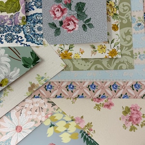 May include: A collection of overlapping rectangular paper samples featuring various floral and geometric patterns. The designs include pink roses on gray, yellow flowers on white, blue and white tiles, and green foliage on light backgrounds.
