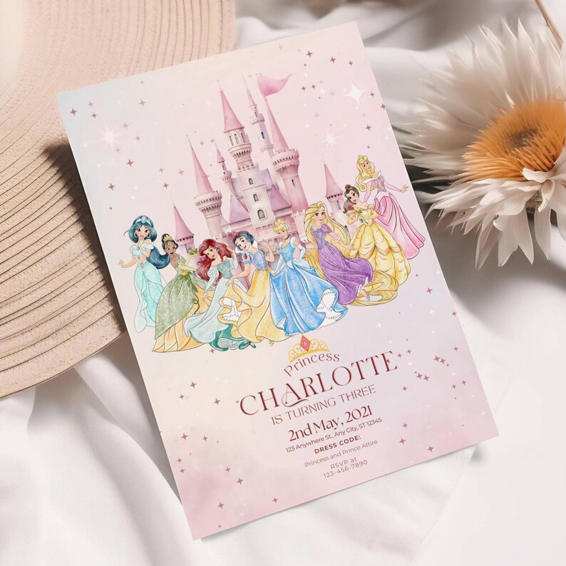 K&ouml;nnte beinhalten: Eine rosa Einladungskarte mit einer Aquarellillustration eines Schlosses und Prinzessinnen. Der Text lautet "Princess Charlotte is turning three" mit Veranstaltungsdetails. Die Karte hat eine weiche, vertr&auml;umte &Auml;sthetik.
