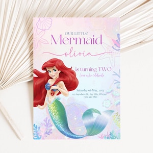May include: A mermaid-themed invitation with the text "Our Little Mermaid Olivia is turning TWO." The invitation features an illustration of a mermaid with red hair and a green tail. The date is Saturday, May 6, 2023.