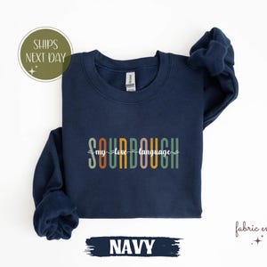 May include: Navy blue sweatshirt with the text "SOURDOUGH my love language" in colourful letters.