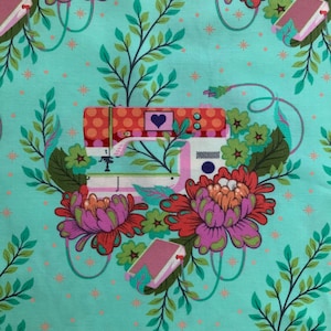 Op de afbeelding: Een licht turquoise stof met een herhalend patroon van naaimachines met oranje stippen, een paars hart en groene bladeren. Het ontwerp bevat grote rode en paarse bloemen, kleine oranje sterretjes en roze elektrische snoeren.
