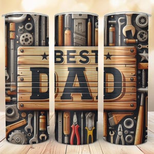 May include: A stainless steel tumbler with a design featuring tools and the words "BEST DAD" on a wooden plank. The design includes wrenches, gears, and other hardware elements, with a dark background.