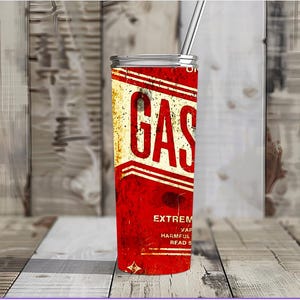May include: A red and white stainless steel tumbler with a vintage gas can design. The tumbler has the word "GAS" in large white letters and the text "EXTREMELY FLAMMABLE VAPORS HARMFUL OR FATAL IF SWALLOWED READ CAREFULLY" in smaller white letters.