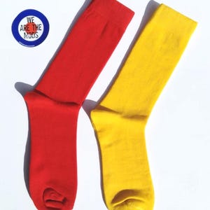 May include: A pair of socks, one red and one yellow. The socks are plain and have no patterns.