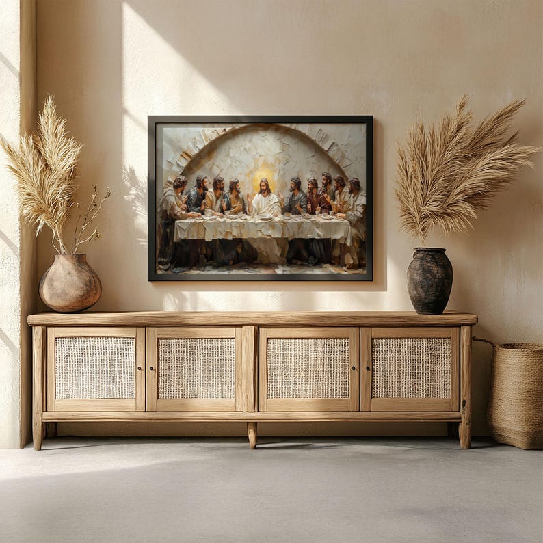 May include: A framed artwork depicting the Last Supper scene, with figures gathered around a table. The artwork is displayed above a light wood cabinet with woven door panels. Decorative vases with dried plants flank the artwork.