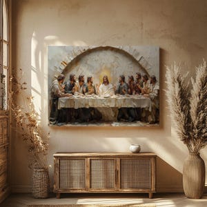 May include: A framed artwork depicting the Last Supper, with Jesus and his disciples seated at a table. The painting is mounted above a wooden cabinet with woven doors. The room has a neutral color palette with natural light and decorative plants.