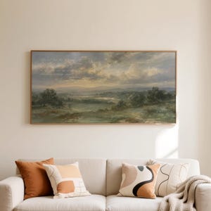 May include: A rectangular landscape wall art print featuring a panoramic view of a rolling green valley under a dramatic, cloudy sunset sky. The artwork includes faint, cursive white text overlaid on the upper left portion of the sky.