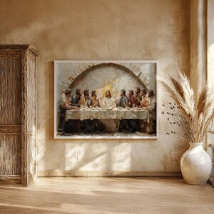 May include: A framed artwork depicting the Last Supper, with Jesus and his disciples seated at a table. The painting has a textured, three-dimensional effect, with a warm, neutral color palette. The artwork is displayed on a beige wall.
