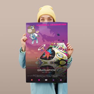May include: A poster with the album art for "Graduation" by Kanye West. The artwork features a cartoon bear in a jacket and a spaceship-like vehicle against a purple and orange sky. The album title is at the top, with song titles at the bottom.