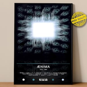 May include: A black framed poster featuring the album art for Tool's "Ænima" album. The artwork has a dark background with a bright, white square in the center, surrounded by a swirling, textured pattern. The album title and band name are at the bottom.