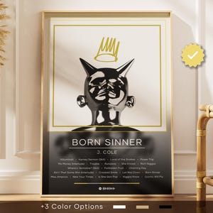 Könnte beinhalten: Gerahmter Kunstdruck mit einer metallischen Skulptur mit Hörnern und einer Krone, betitelt "BORN SINNER" von J. Cole. Der Druck enthält eine Titelliste und wird in einem goldenen Rahmen präsentiert. Das Kunstwerk wird mit drei Farboptionen angeboten.