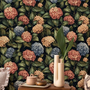 May include: A floral wallpaper with a dark background featuring a repeating pattern of pink, blue, and cream hydrangeas with green leaves.