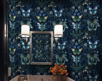 May include: A bathroom with a dark blue floral wallpaper featuring butterflies and flowers in shades of blue and green. A silver framed mirror hangs above a white sink with silver fixtures. Two white lamps flank the mirror.