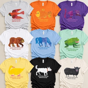 May include: A collection of nine short-sleeved t-shirts in various colors, each featuring a unique animal illustration and the corresponding text, such as Red Bird, Goldfish, Purple Cat, Brown Bear, Blue Horse, Green Frog, Yellow Duck, White Dog, and Black Sheep.