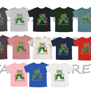 May include: A collection of children's t-shirts in various colors, each featuring a colorful graphic of a caterpillar and the text "ONE" and "Hungry Caterpillar". The shirts are short-sleeved.