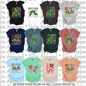 May include: A collection of colorful t-shirts featuring various designs and text. The shirts display phrases like "DADA," "BROTHER," and "GIGI," along with illustrations of a caterpillar. The text "WE OFFER OTHER COLORS AS WELL PLEASE CONTACT US" is also visible.