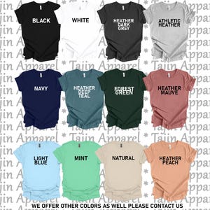 May include: A collection of short-sleeved t-shirts in various colors, including black, white, navy, and light blue. Each shirt displays a color name in bold text. The text "WE OFFER OTHER COLORS AS WELL PLEASE CONTACT US" is at the bottom.