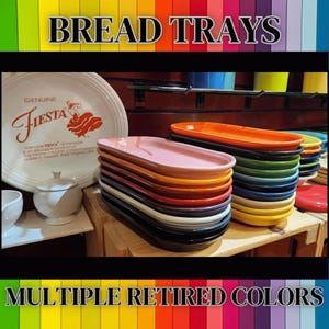 May include: A stack of colorful, oval-shaped bread trays in various colors, including pink, orange, and black. The trays are stacked on a wooden surface. The image also shows a white Fiesta plate with the text "Genuine Fiesta" and "Multiple Retired Colors".