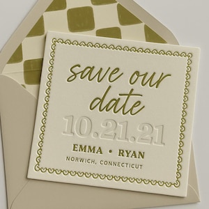 以下が含まれることがあります： クリーム色の結婚式の招待状。緑色の筆記体で「save our date」と書かれています。「10.21.21」の日付、名前「Emma • Ryan」、場所「Norwich, Connecticut」も印刷されています。封筒は緑色のチェック柄です。