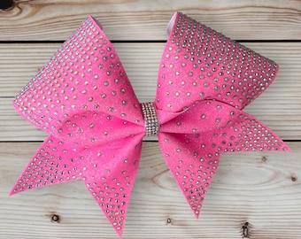 May include: A pink cheer bow with silver glitter and rhinestones.