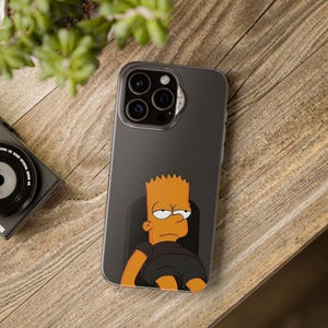 Puede incluir: Una funda de teléfono negra con una imagen de dibujos animados de Bart Simpson de Los Simpson. Bart está sentado en una silla con una expresión aburrida en su rostro.