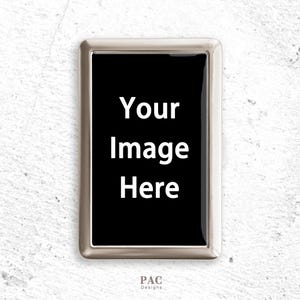 May include: A rectangular silver-toned metal case featuring a central black panel with the white text Your Image Here. The case has a smooth, polished metallic frame and a hinge on the right side. Below the case, the text PAC Designs is visible.