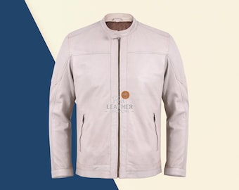 May include: A white leather jacket with a zipper closure and a stand-up collar. The jacket has two zippered pockets on the front and a logo on the chest that says "Leather Traditions".