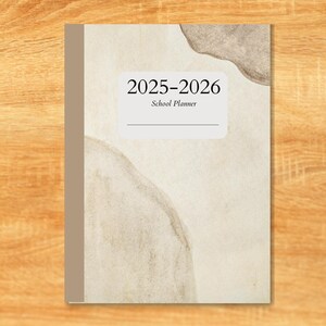 May include: A 2025-2026 school planner with a neutral colour scheme. The cover has abstract watercolour-style shapes in grey and beige. The title is in a clean, modern font. The planner is designed for the academic year.